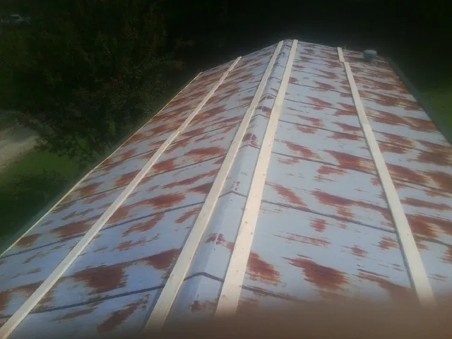 Rusted metal roof panels with new wood purlins before replacement — Storm Damage Roof Repair in East Syracuse by Roofing Brothers