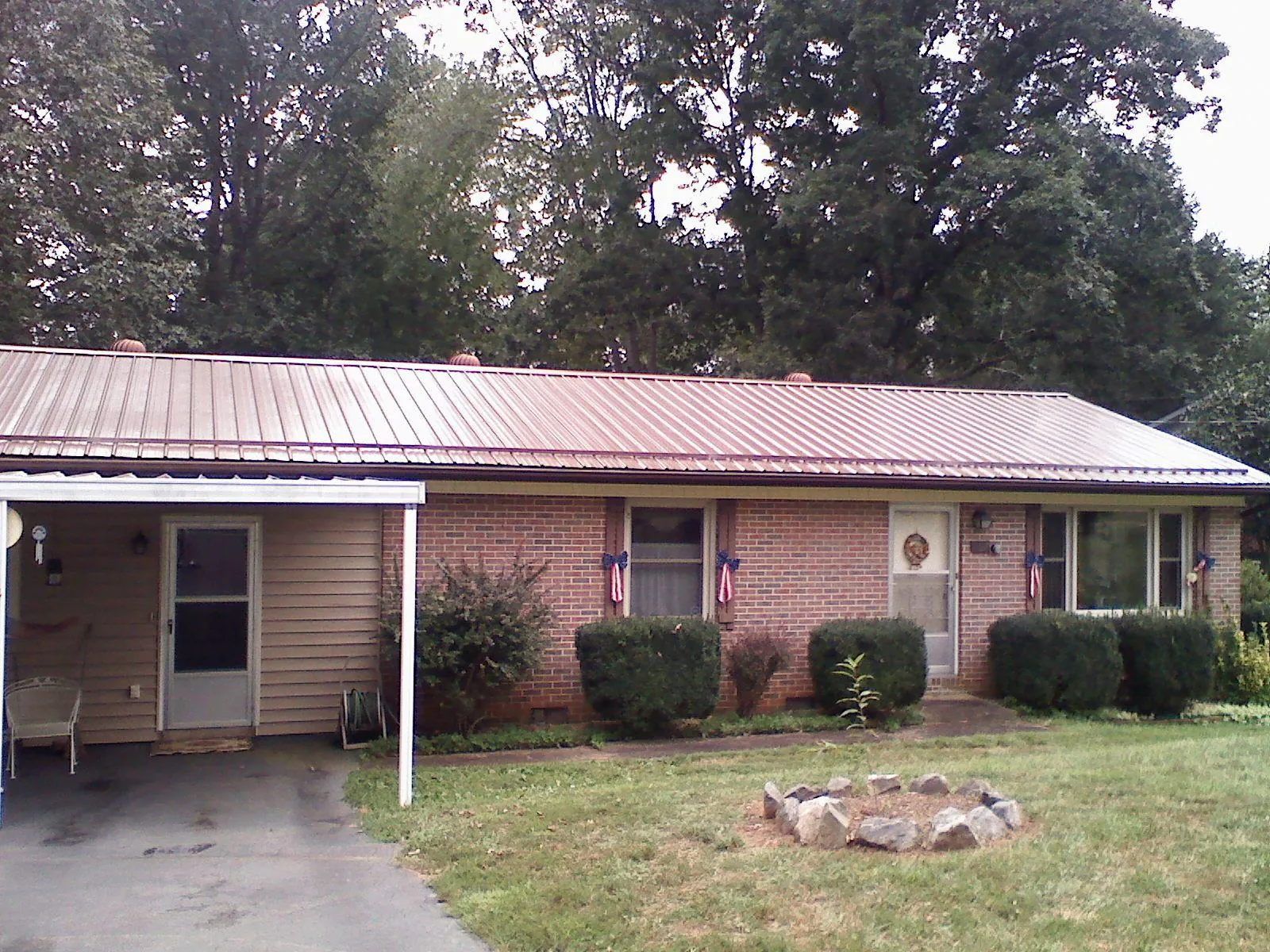 Bronze metal roof and carport on a brick ranch home — Roof Repair work by our crew in East Syracuse